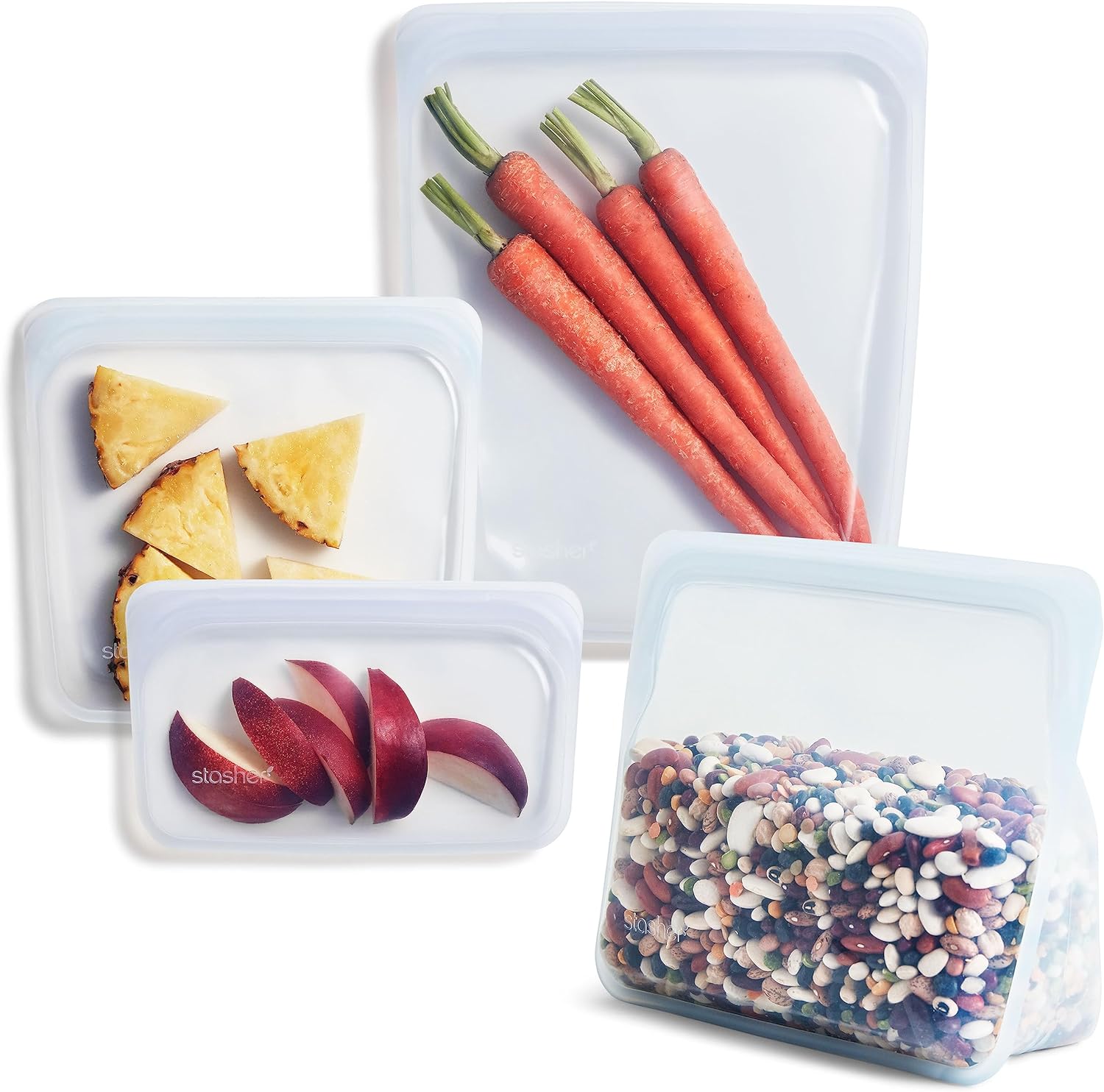 Stasher silicone bags in four sizes laid out on a kitchen counter with food inside